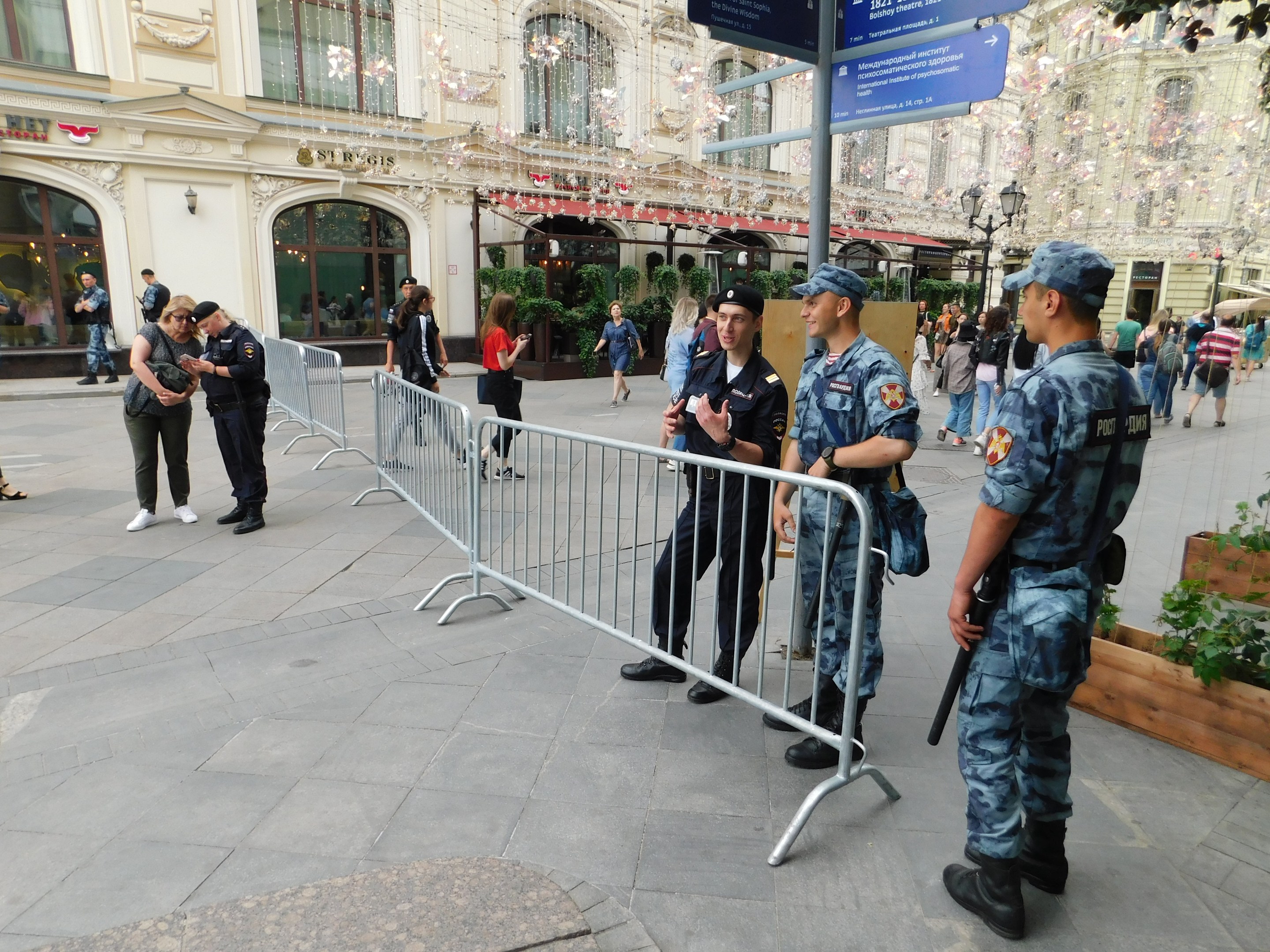 Polizeibeamte in Uniform stehen hinter Absperrungen und blicken auf eine Menge, einige tragen Mützen und halten Waffen, während sie einen Anti-Terror-Einsatz in Wien, Österreich, durchführen.