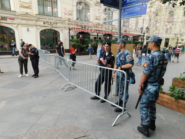 Polizeibeamte in Uniform stehen hinter Absperrungen und blicken auf eine Menge, einige tragen Mützen und halten Waffen, während sie einen Anti-Terror-Einsatz in Wien, Österreich, durchführen.