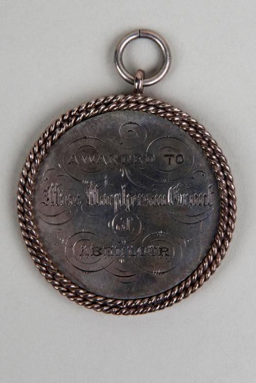 Eine Silbermedaille mit einer Schnur drumherum, darauf die Inschrift "Verliehen an den Metropolitan Council" in schwarzer Tinte mit einem dekorativen Rahmen.