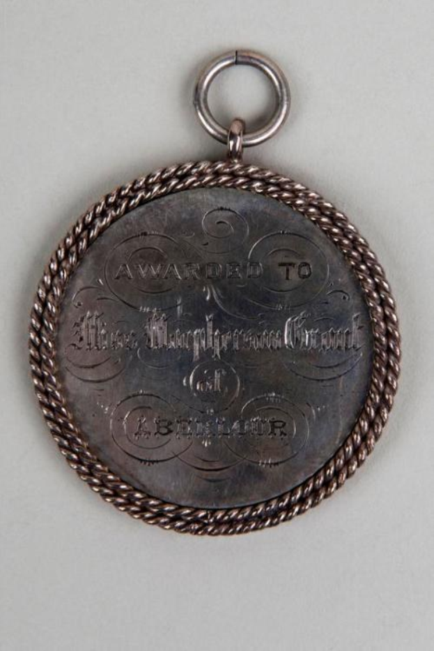 Eine Silbermedaille mit einer Schnur drumherum, darauf die Inschrift "Verliehen an den Metropolitan Council" in schwarzer Tinte mit einem dekorativen Rahmen.
