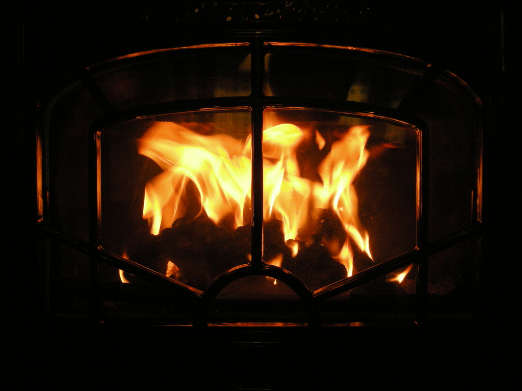 Ein Feuer brennt in einem Kamin aus Brennholz.