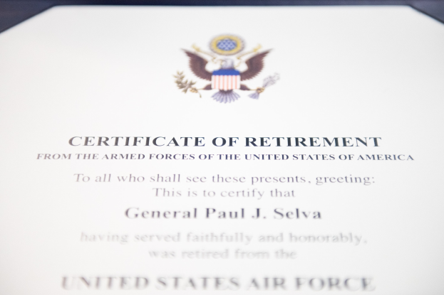 Blau gerahmtes Entlassungszertifikat der United States Air Force mit einem zentralen Sternemblem, das von einem Lorbeerkranz umgeben ist und eine 'Entlassung' -Banderole trägt.