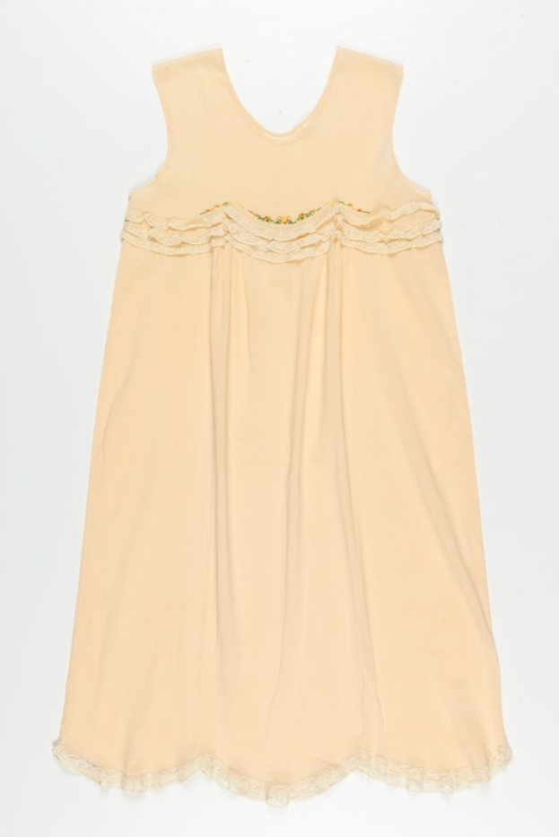 Ein cremefarbenes Nachthemd mit zarter Spitzenborte am Ausschnitt, aus weichem, leichtem Stoff mit einem dezenten Schimmer.