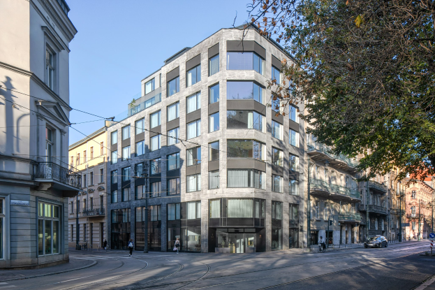 Großes Bürogebäude mit zahlreichen Fenstern, umgeben von Straßeninfrastruktur, Fahrzeugen, Fußgängern, Bäumen und einem bewölkten Himmel als neue Firmenzentrale.