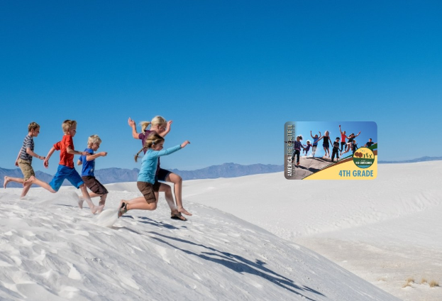 Gruppe von Kindern, die über eine weiße Sanddüne im Death Valley National Park laufen, mit Hügeln im Hintergrund und einem klaren blauen Himmel, mit einer Werbekarte auf der rechten Seite.