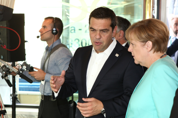 Bundeskanzlerin Angela Merkel und Bundeskanzler Joachim Gauck vor einer Glaswand mit Vorhang, beide im Anzug und mit Mikrofonen.