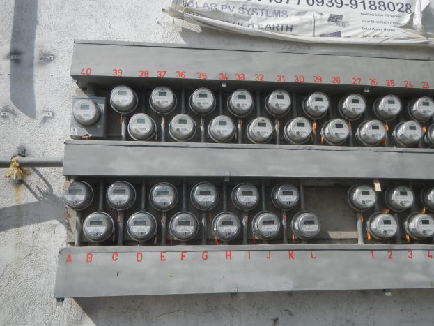 Nahaufnahme eines elektrischen Zählers an der Seite eines Gebäudes mit einem Banner mit Text oben