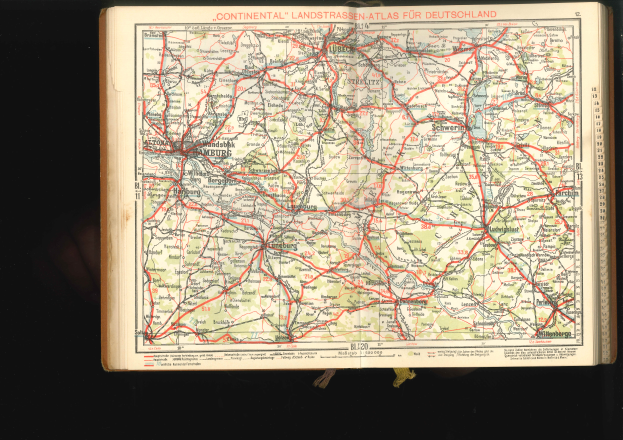 Ein aufgeschlagenes Buch mit einer detaillierten Deutschlandkarte, die auf einem dunklen Hintergrund dargestellt ist.