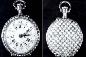 Eine silberne Taschenuhr mit Diamanten, die in einem runden Gehäuse mit römischen Ziffern auf einem schwarzen Hintergrund eingelassen sind.
