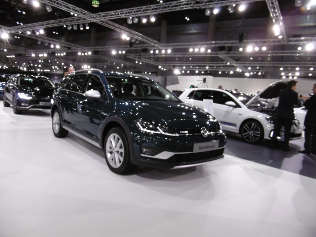 Ein Volkswagen Golf Alltrack auf der IAA in Frankfurt, umgeben von Menschen und von Deckenlampen beleuchtet.