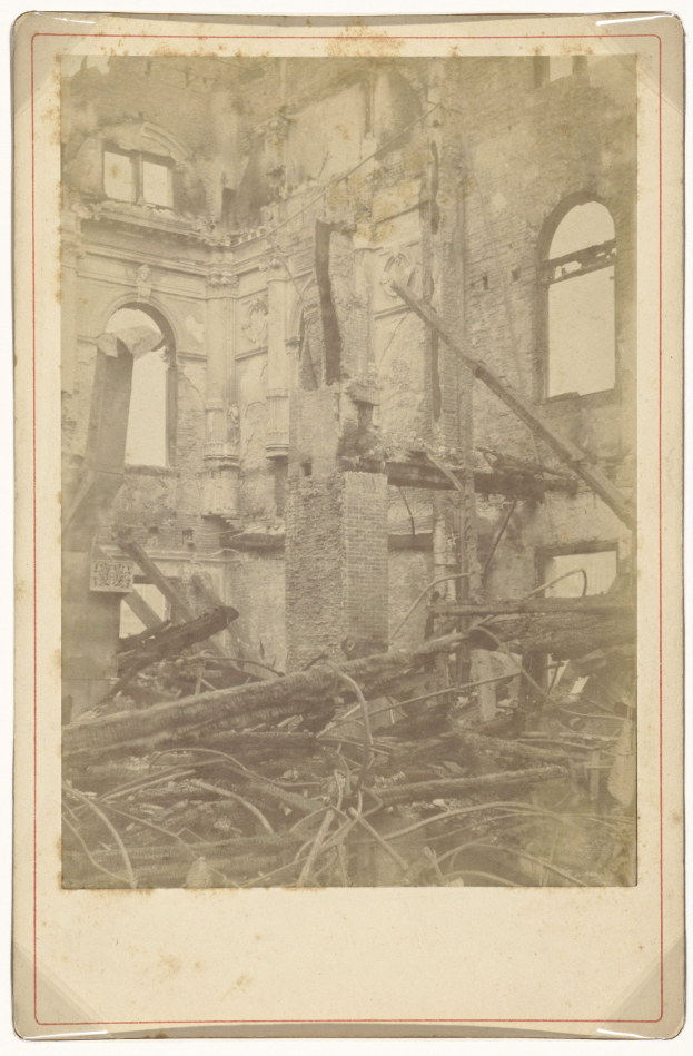 Altes Foto eines baufälligen Gebäudes mit bröckelnden Wänden, zerbrochenen Fenstern und verstreuten Holztrümmern.