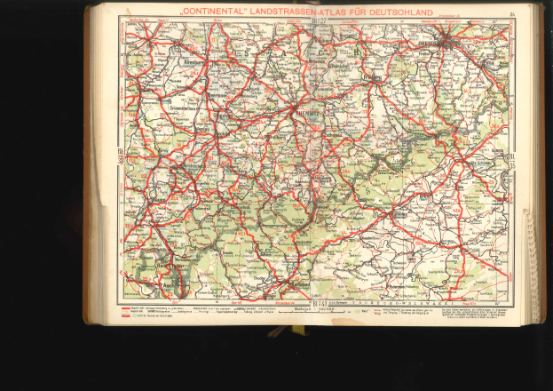 Offenes Buch mit einem detaillierten Kartenausschnitt von Deutschlands Straßen und Autobahnen auf schwarzem Hintergrund.