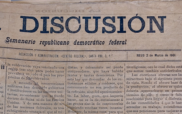 Eine gelbliche, leicht zerknitterte Zeitung mit der schwarzen Schrift 'Diskussion', auf der die Schlagzeile 'Semanario Repúblicano Democrático Federal' steht.