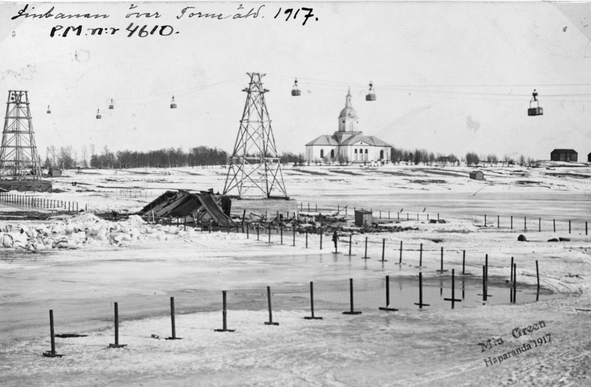 Schwarzes und weißes Foto einer Skipiste im Schnee mit Stützen und Türmen, Häusern, Bäumen und einem Gebäude im Hintergrund, mit Text oben.