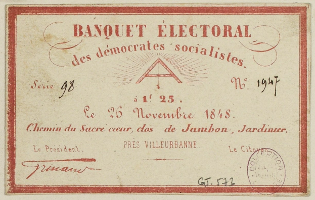 Ein alter Umschlag mit einem roten Rand und einer Briefmarke, beschriftet mit 'Banquet Electoral des Democrats Socialists'.