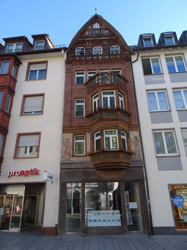 Gewerbliches Eigentum zum Verkauf in Heidelberg, Deutschland, mit einem mehrfenstrigen Gebäude neben einer Straße unter einem klaren blauen Himmel.