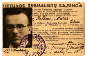 Ein alter Pass mit einem Foto eines Mannes mit Brille, einem Stempel und Text mit persönlichen Informationen.